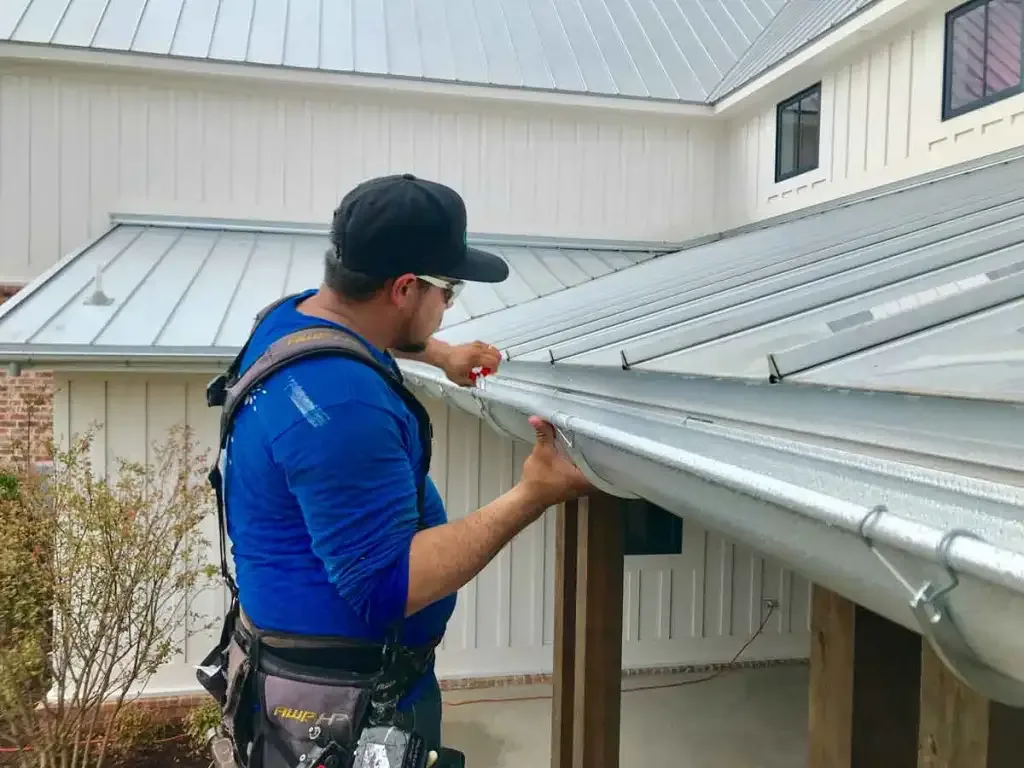 New seamless gutter and downspout directing water away from the foundation